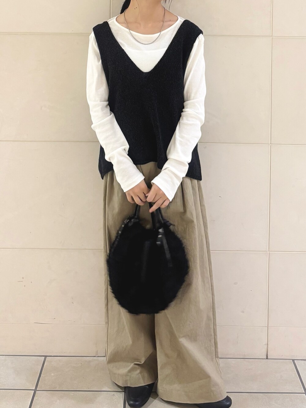 ブラック系のニット/セーター、グリーン系のTシャツ/カットソー、ベージュ系のその他パンツを着用したレディースの秋コーディネートの4枚目の写真