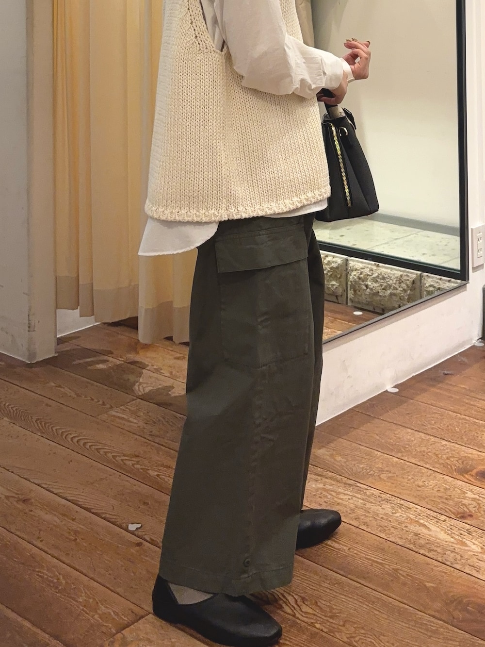 グリーン系のその他パンツ、ブラック系のハンドバッグ、ホワイト系のシャツ/ブラウスを着用したレディースの冬コーディネートの6枚目の写真