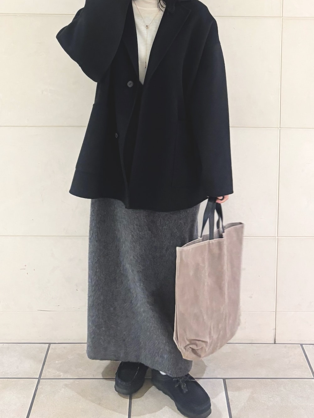 ホワイト系のニット/セーター、グレー系のワンピース、グレー系のトートバッグを着用したレディースの冬コーディネートの4枚目の写真