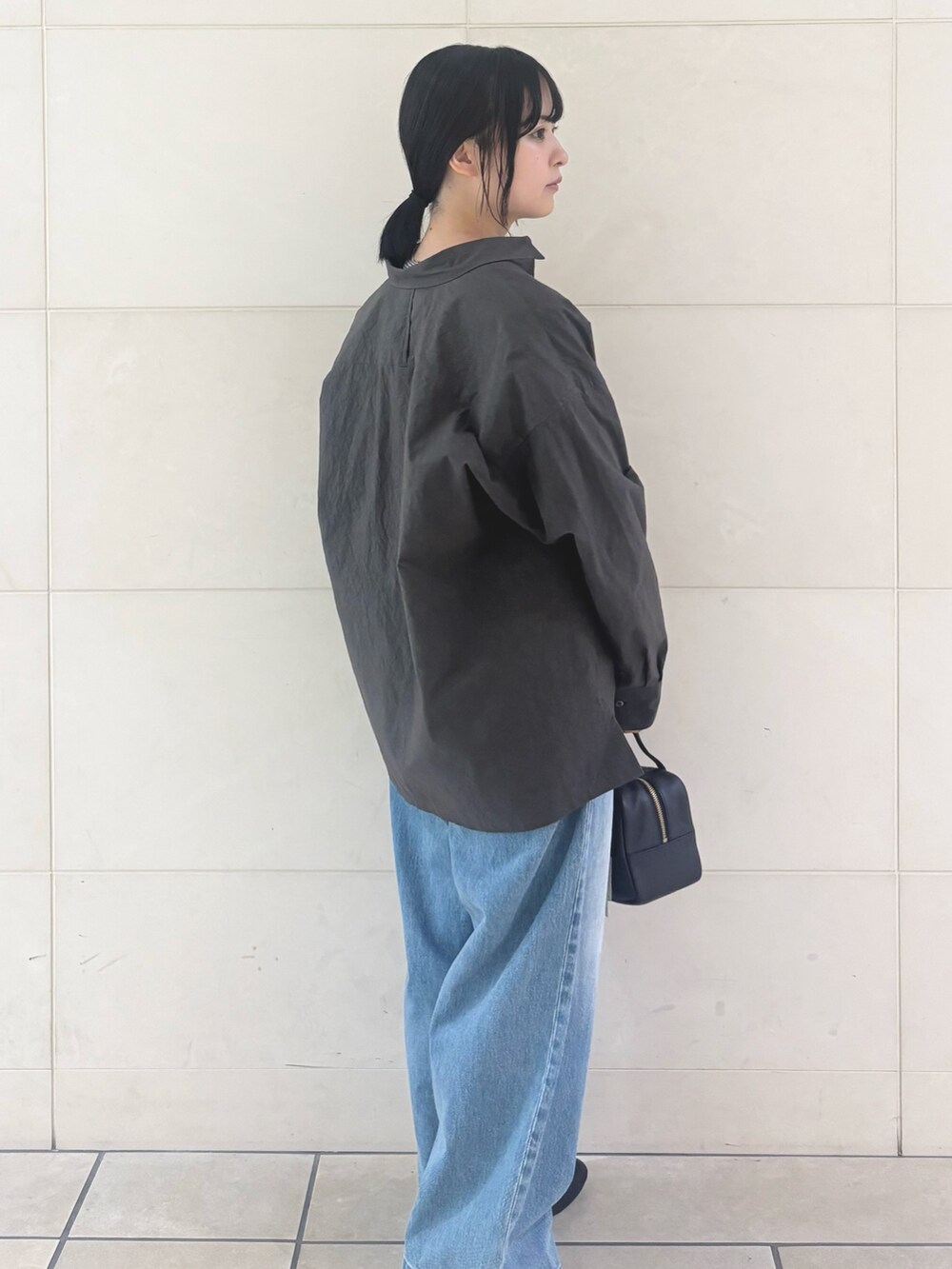 ブルー系のデニムパンツ、ブラック系のパンプスを着用したレディースの秋コーディネートの4枚目の写真