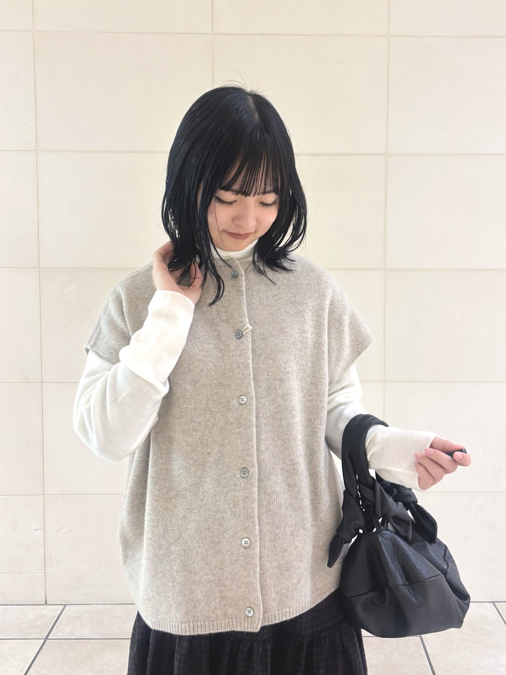 ベージュ系のニット/セーター、ホワイト系のニット/セーター、ブラウン系のスカートを着用したレディースの秋コーディネートの4枚目の写真