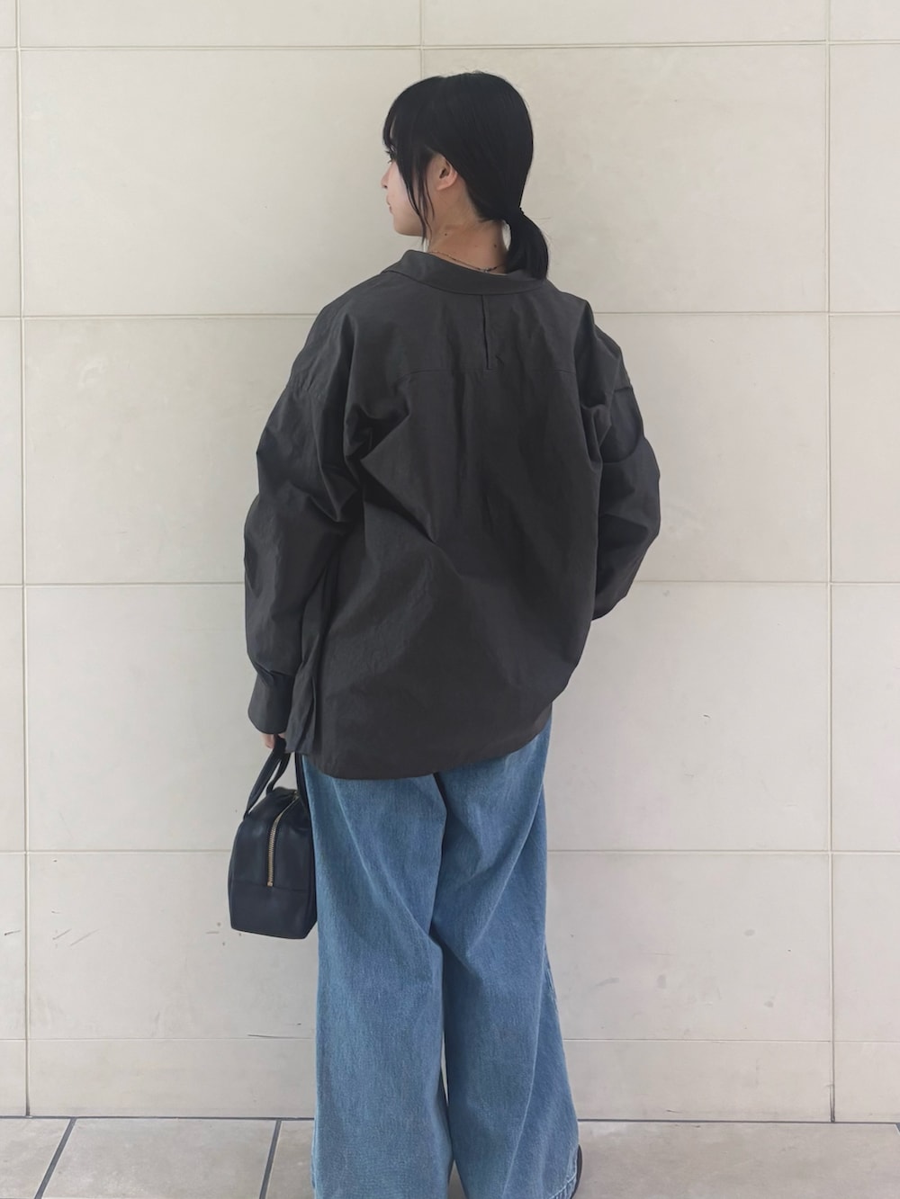 ブルー系のデニムパンツ、ブラック系のパンプスを着用したレディースの秋コーディネートの3枚目の写真