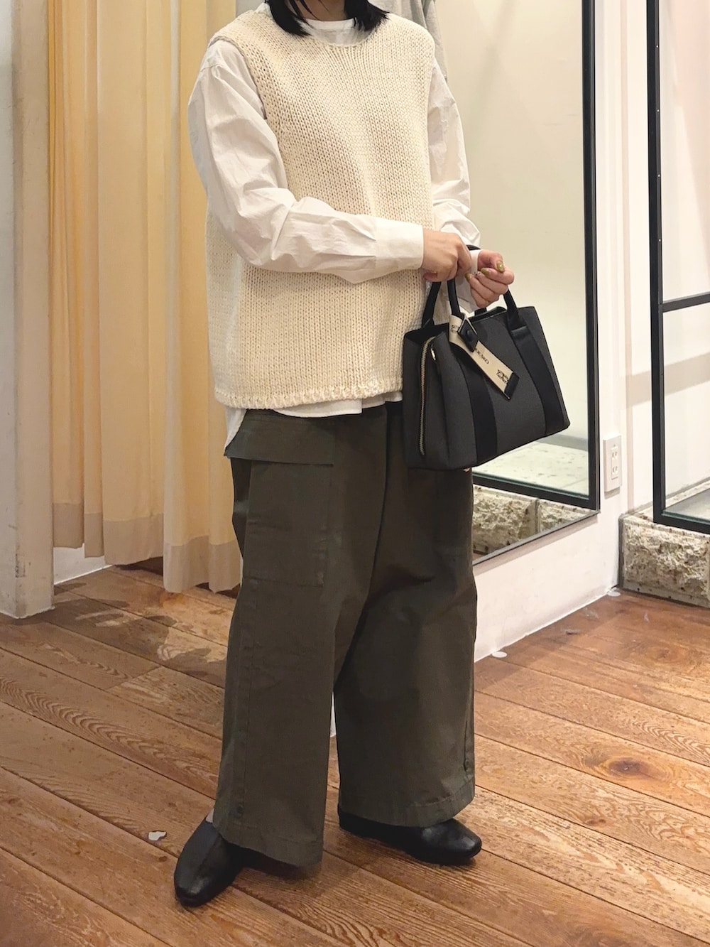 グリーン系のその他パンツ、ブラック系のハンドバッグ、ホワイト系のシャツ/ブラウスを着用したレディースの冬コーディネートの5枚目の写真