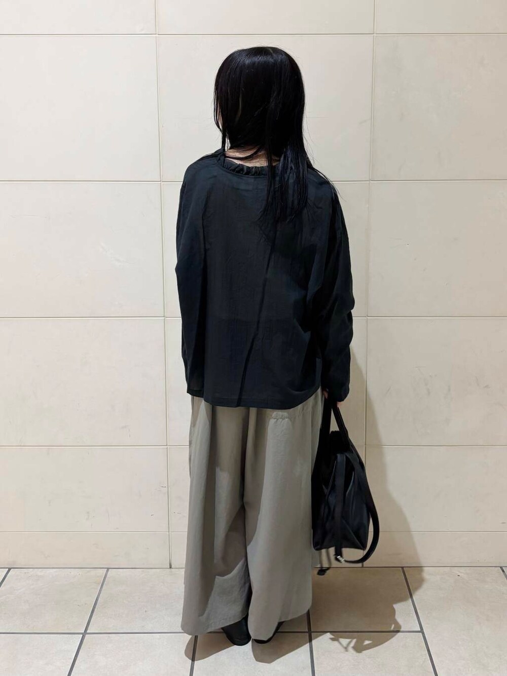 ブラック系のパンプス、ブラック系のショルダーバッグ、ホワイト系のタンクトップを着用したレディースの夏コーディネートの4枚目の写真