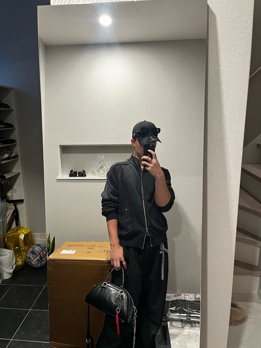 グレー系のカーディガン/ボレロ、ブラック系のパーカー、ブラック系のデニムパンツを着用したメンズの春コーディネートの2枚目の写真