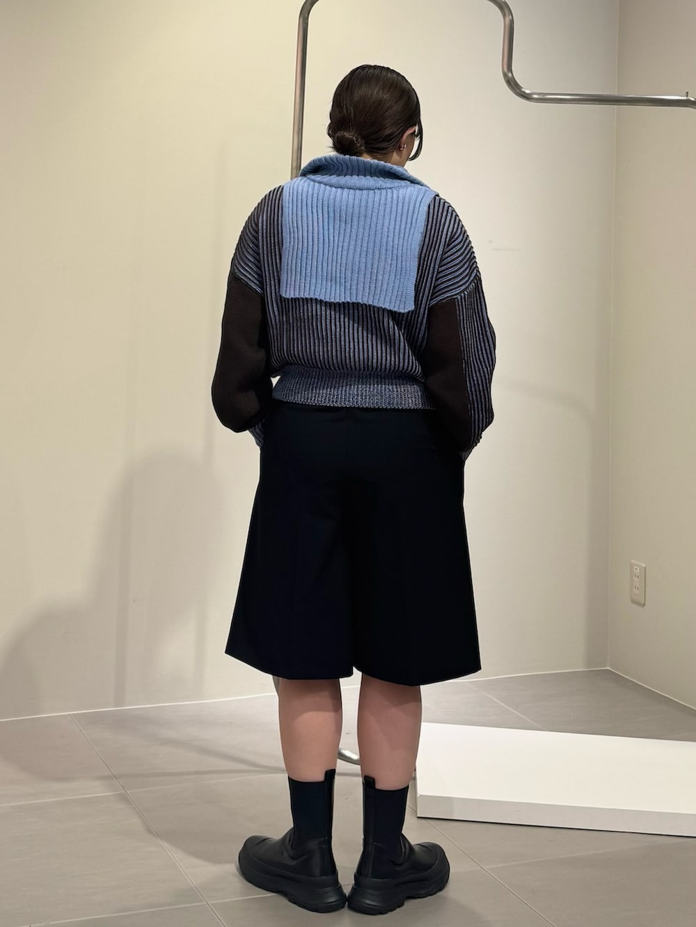 ブラック系のブーツ、ブラック系のショルダーバッグ、グレー系のニット/セーターを着用したレディースの秋コーディネートの5枚目の写真