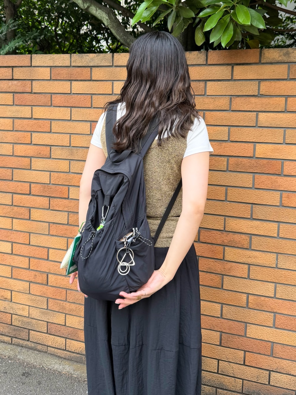 ブラック系のその他パンツ、ブラウン系のショルダーバッグ、ブラウン系のタンクトップを着用したレディースの夏コーディネートの6枚目の写真