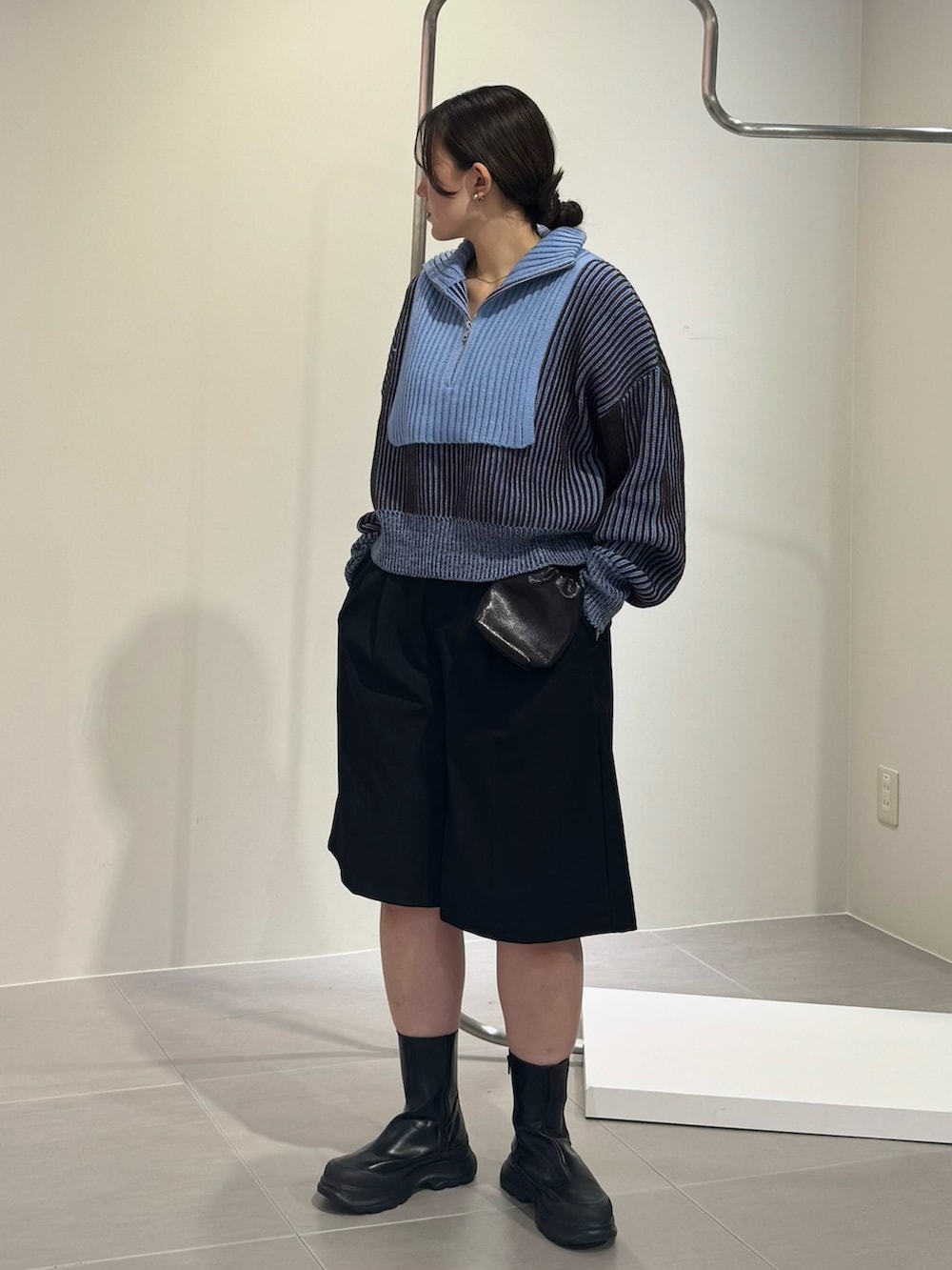 ブラック系のブーツ、ブラック系のショルダーバッグ、グレー系のニット/セーターを着用したレディースの秋コーディネートの4枚目の写真