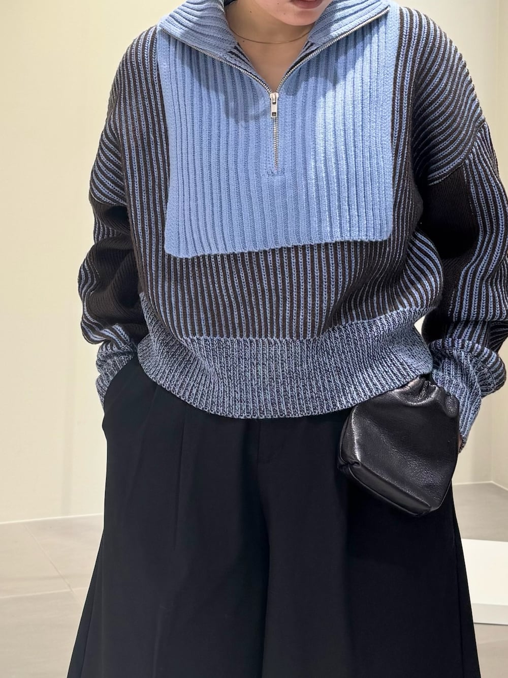 ブラック系のブーツ、ブラック系のショルダーバッグ、グレー系のニット/セーターを着用したレディースの秋コーディネートの6枚目の写真