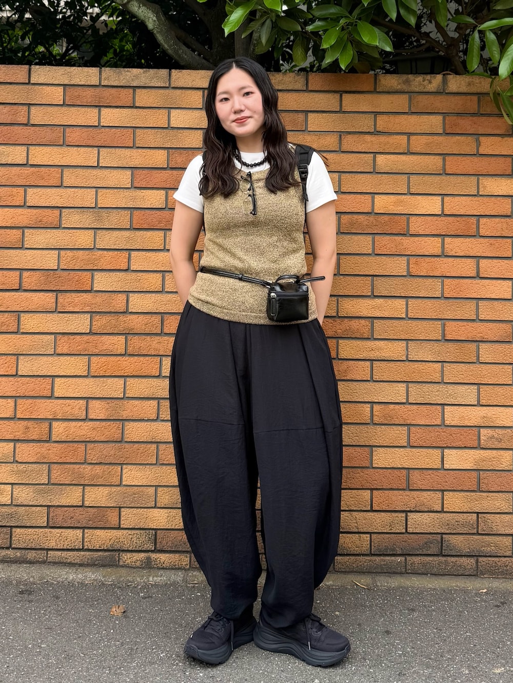 ブラック系のその他パンツ、ブラウン系のショルダーバッグ、ブラウン系のタンクトップを着用したレディースの夏コーディネートの2枚目の写真