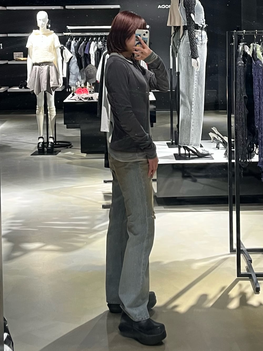 ブルー系のデニムパンツ、グレー系のTシャツ/カットソー、ブラック系のブーツを着用したレディースの春コーディネートの2枚目の写真