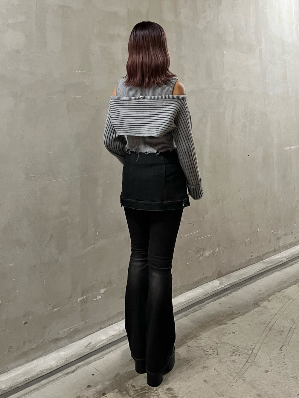 グレー系のニット/セーター、ブラック系のデニムパンツ、ブラック系のブーツを着用したレディースの秋コーディネートの3枚目の写真