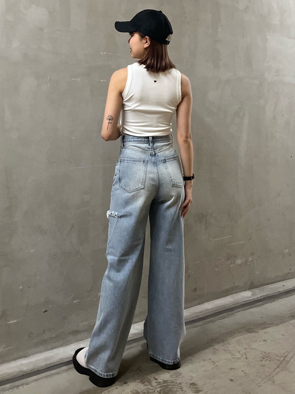 ブルー系のデニムパンツ、ホワイト系のタンクトップ、ホワイト系のサンダルを着用したレディースの夏コーディネートの3枚目の写真