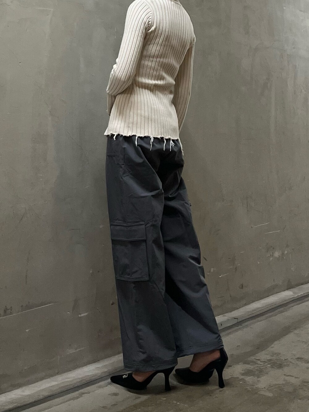 ホワイト系のニット/セーター、グレー系のその他パンツ、ブラック系のハンドバッグを着用したレディースの春コーディネートの3枚目の写真