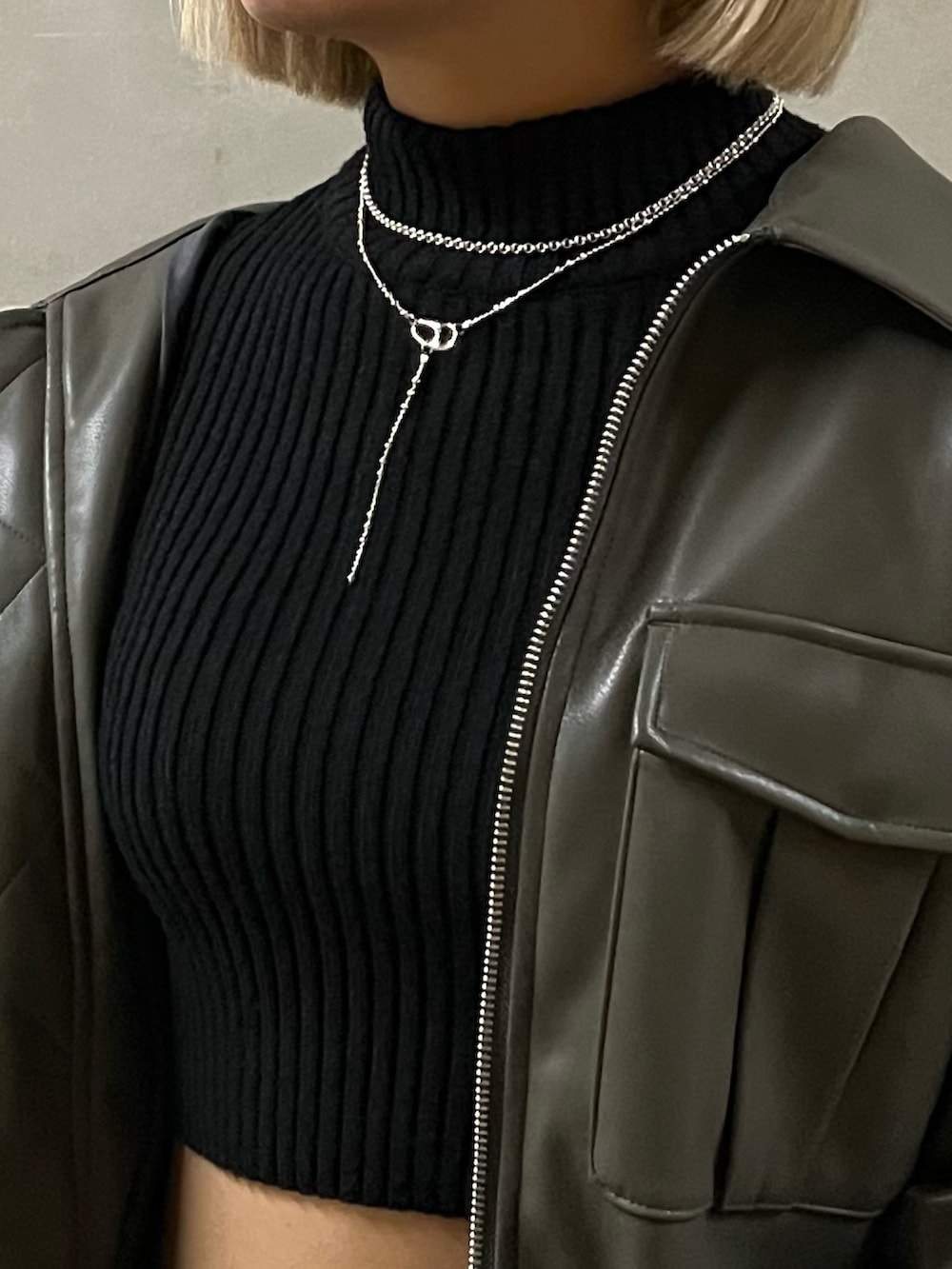 ブラック系のニット/セーター、グレー系のブルゾン、ブラック系のデニムパンツを着用したレディースの冬コーディネートの4枚目の写真