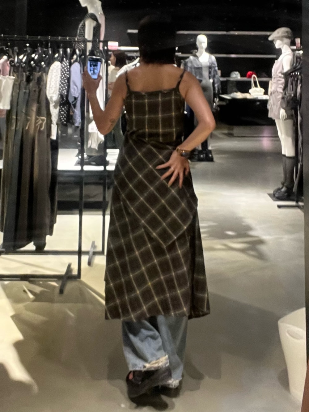 グリーン系のワンピース、ブルー系のデニムパンツ、ブラック系のサンダルを着用したレディースの夏コーディネートの3枚目の写真