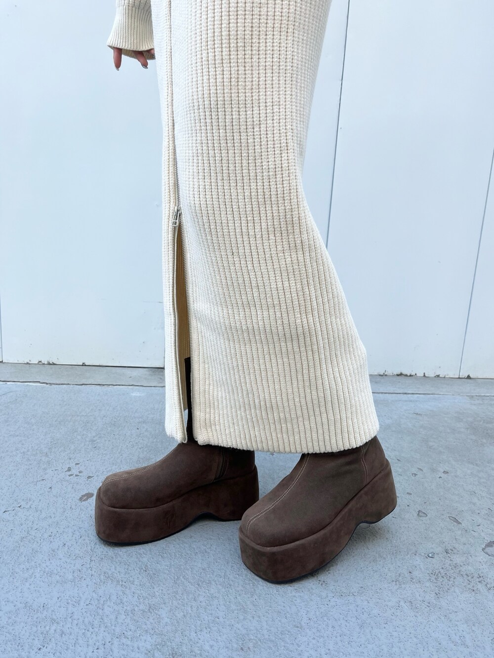 ホワイト系のニット/セーター、ホワイト系のスカート、ブラウン系のブーツを着用したレディースの冬コーディネートの5枚目の写真