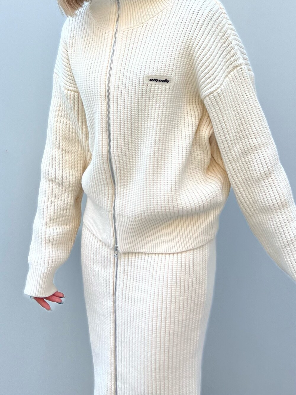 ホワイト系のニット/セーター、ホワイト系のスカート、ブラウン系のブーツを着用したレディースの冬コーディネートの4枚目の写真