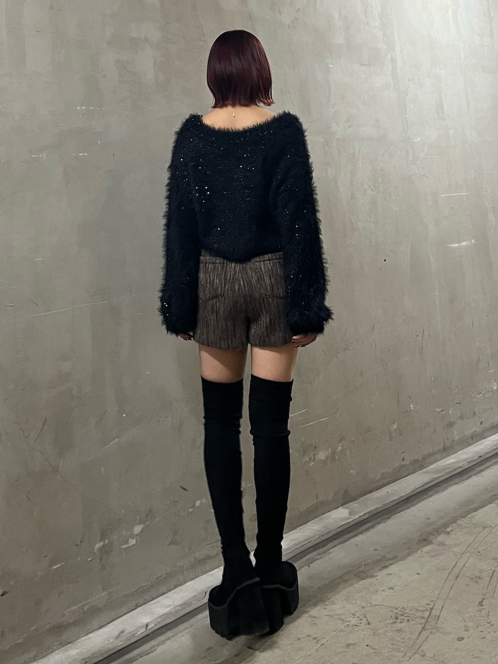 ブラック系のニット/セーター、ブラウン系のその他パンツ、ブラック系のブーツを着用したレディースの冬コーディネートの3枚目の写真