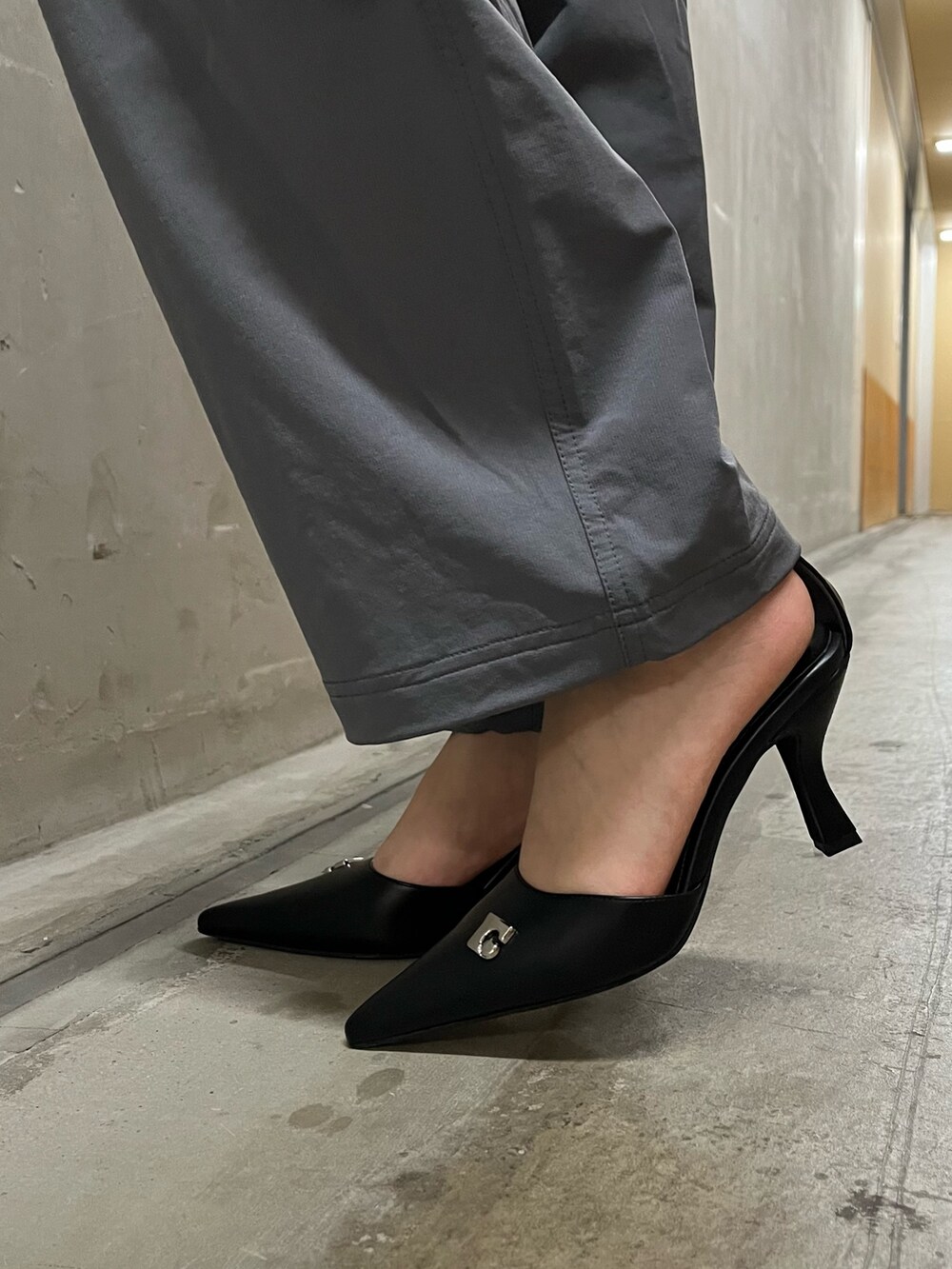 ホワイト系のニット/セーター、グレー系のその他パンツ、ブラック系のハンドバッグを着用したレディースの春コーディネートの5枚目の写真