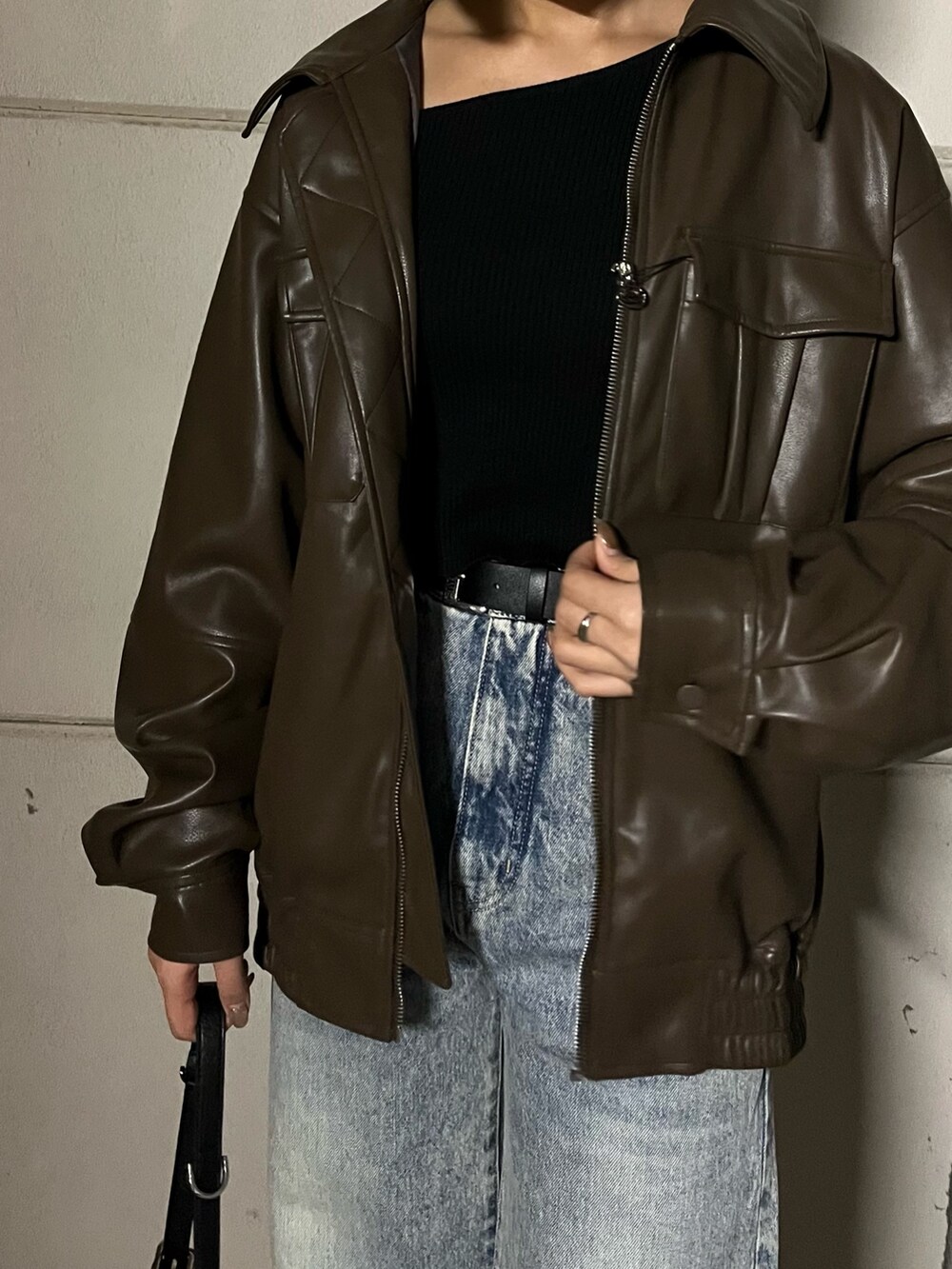 ブラウン系のブルゾン、ブラック系のデニムパンツ、ブラック系のローファーを着用したレディースの冬コーディネートの5枚目の写真