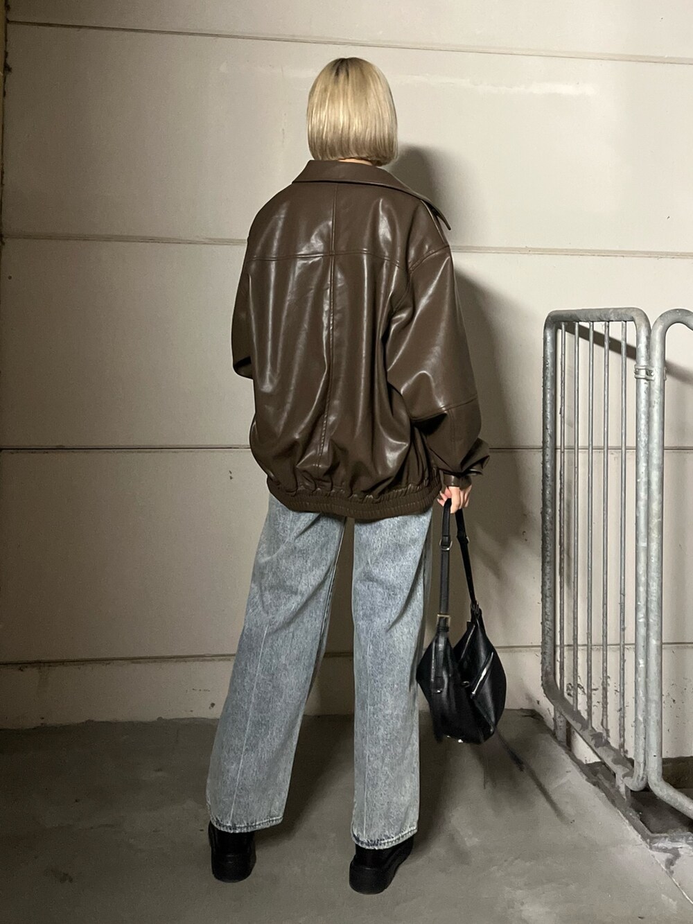 ブラウン系のブルゾン、ブラック系のデニムパンツ、ブラック系のローファーを着用したレディースの冬コーディネートの4枚目の写真