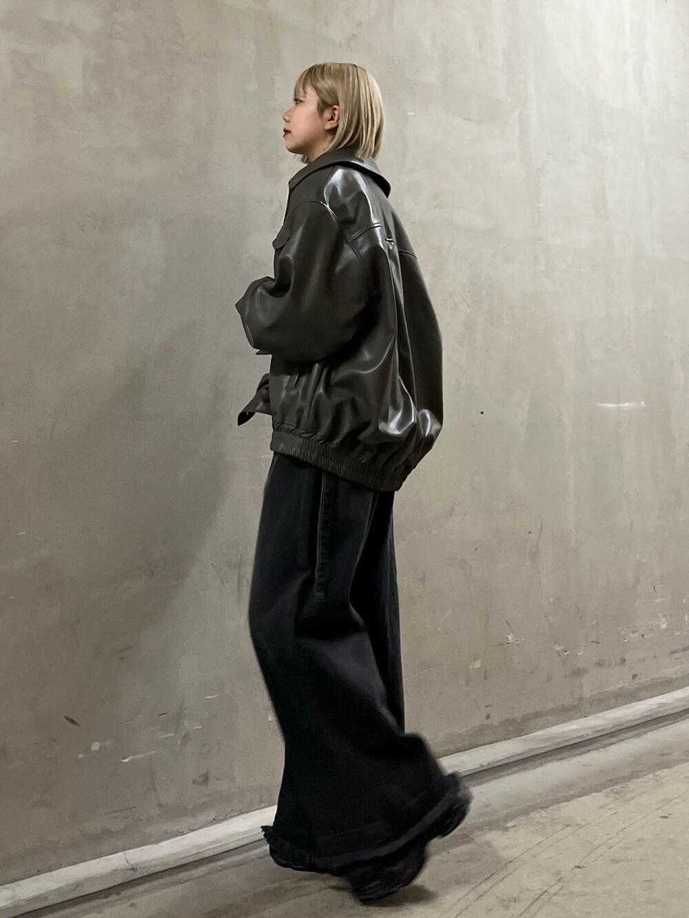 ブラック系のニット/セーター、グレー系のブルゾン、ブラック系のデニムパンツを着用したレディースの冬コーディネートの2枚目の写真