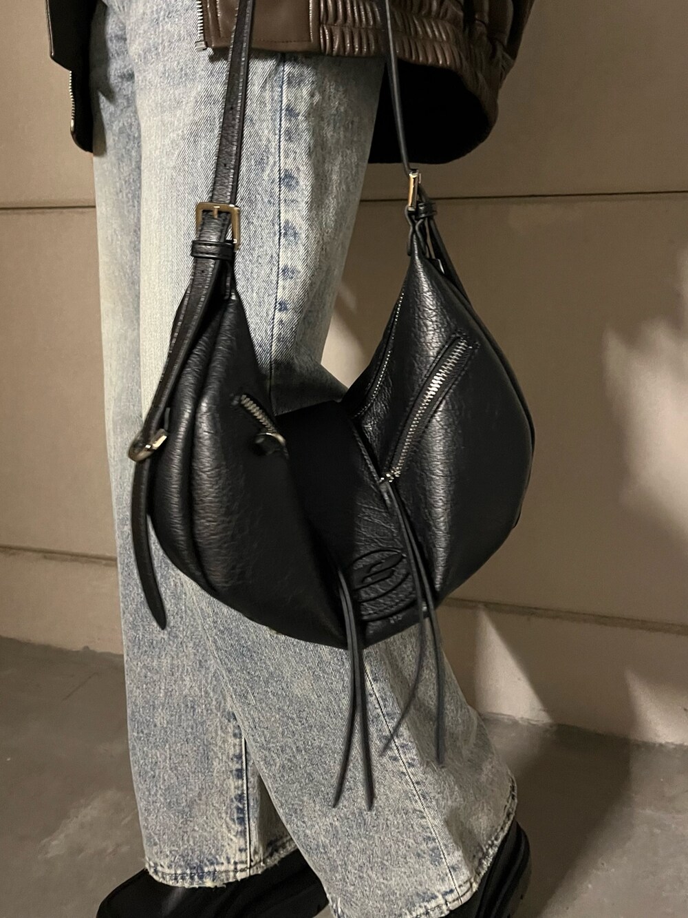 ブラウン系のブルゾン、ブラック系のデニムパンツ、ブラック系のローファーを着用したレディースの冬コーディネートの8枚目の写真