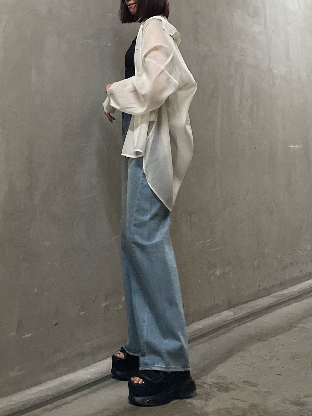 ブラック系のタンクトップ、ホワイト系のシャツ/ブラウス、ブルー系のデニムパンツを着用したレディースの春コーディネートの2枚目の写真