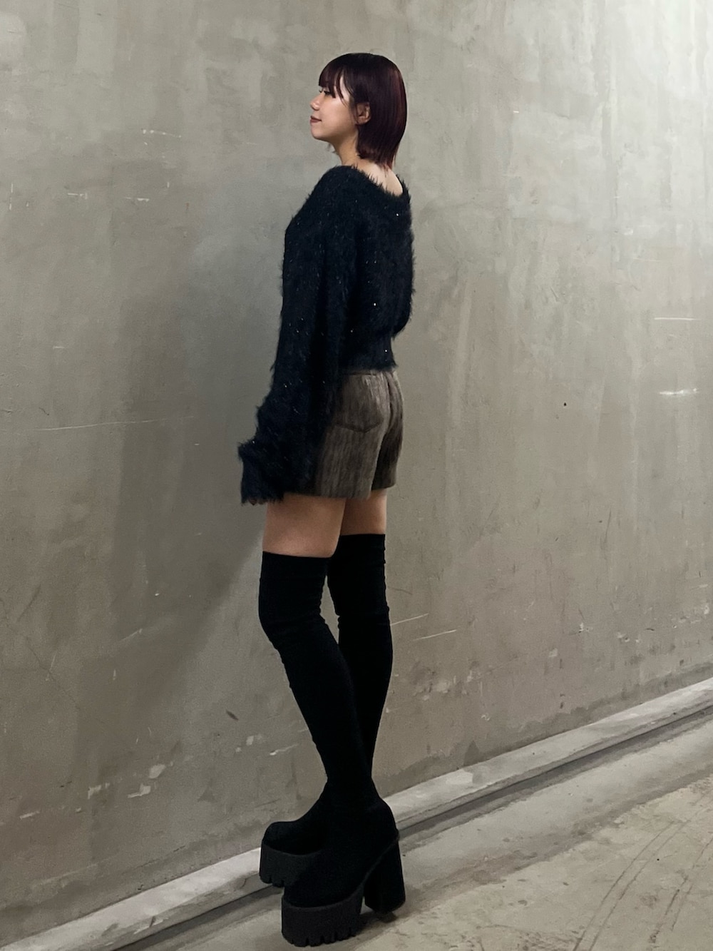 ブラック系のニット/セーター、ブラウン系のその他パンツ、ブラック系のブーツを着用したレディースの冬コーディネートの2枚目の写真