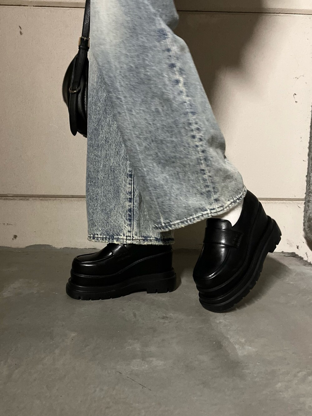 ブラウン系のブルゾン、ブラック系のデニムパンツ、ブラック系のローファーを着用したレディースの冬コーディネートの7枚目の写真