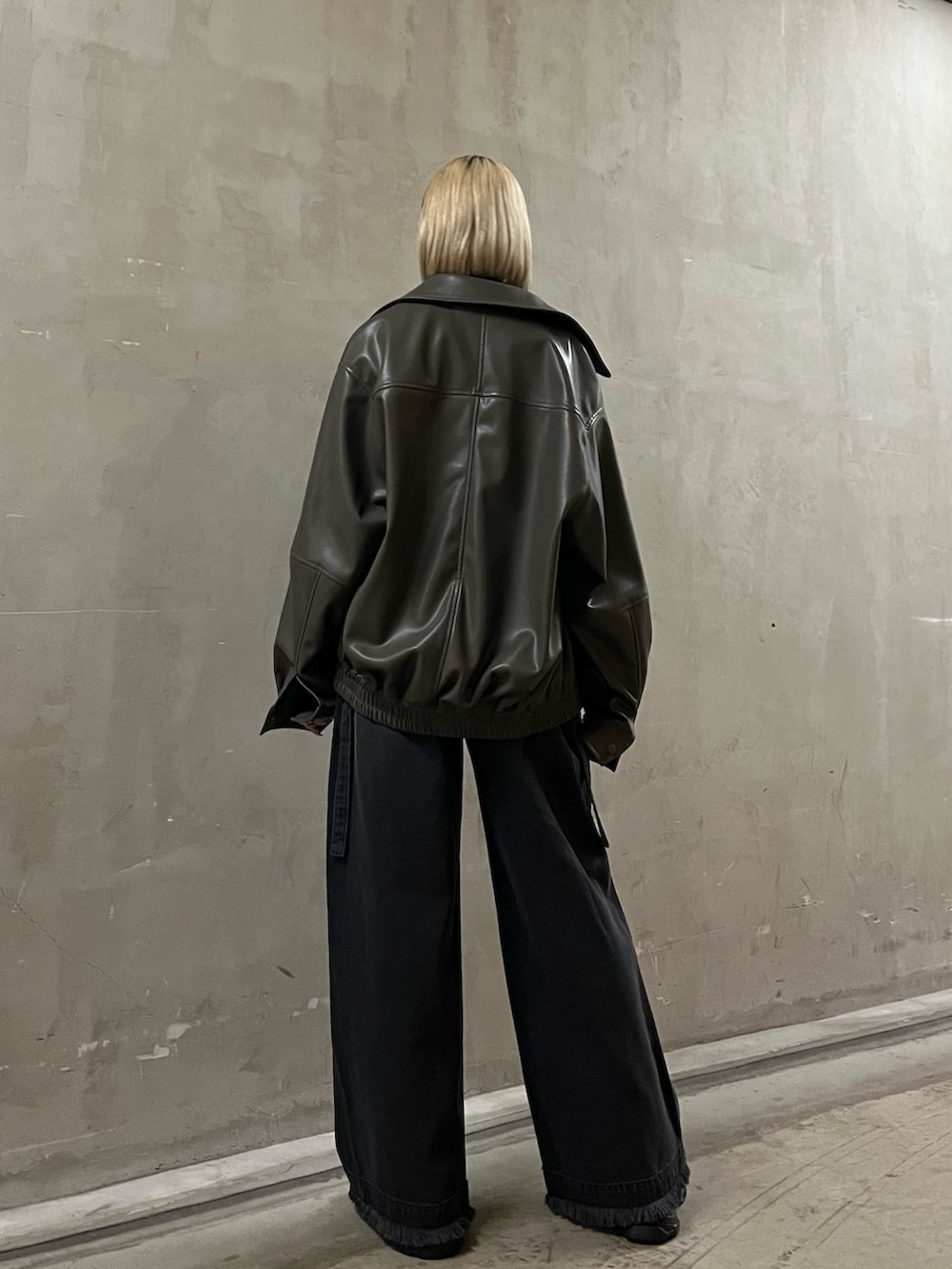 ブラック系のニット/セーター、グレー系のブルゾン、ブラック系のデニムパンツを着用したレディースの冬コーディネートの3枚目の写真