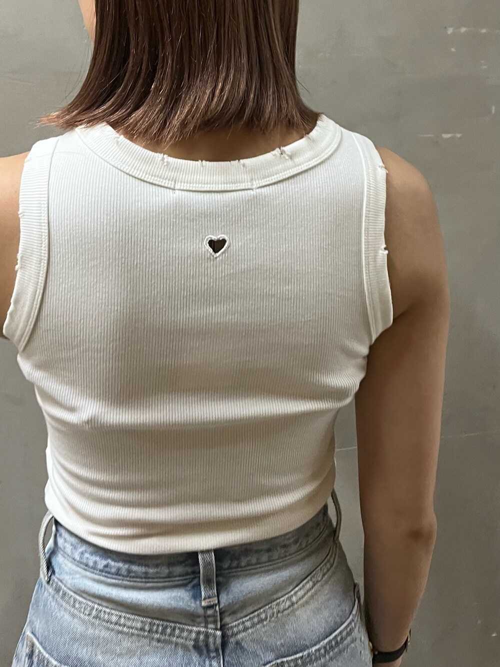 ブルー系のデニムパンツ、ホワイト系のタンクトップ、ホワイト系のサンダルを着用したレディースの夏コーディネートの4枚目の写真