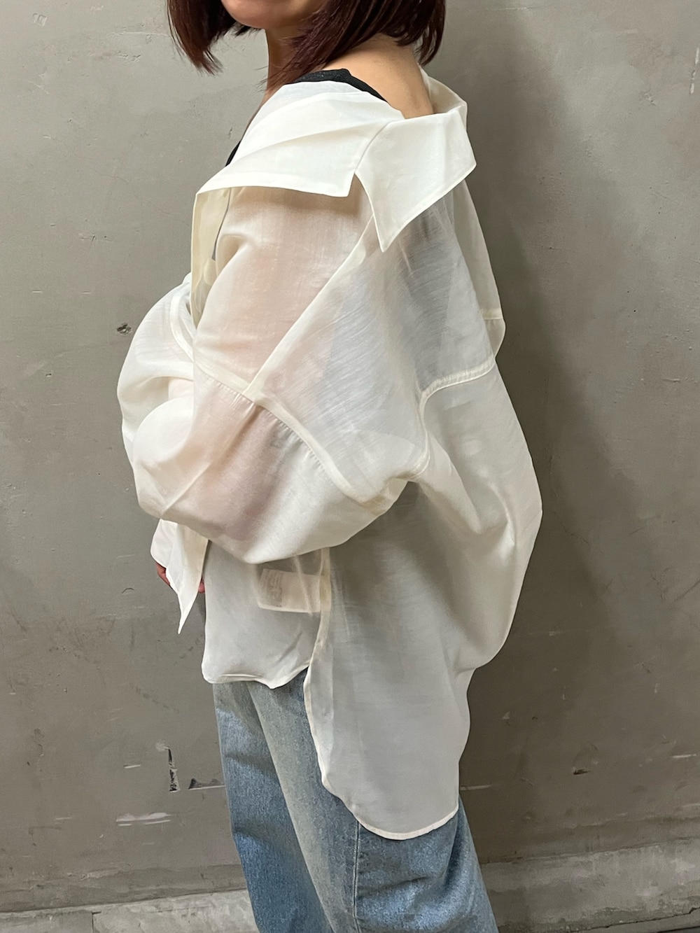 ブラック系のタンクトップ、ホワイト系のシャツ/ブラウス、ブルー系のデニムパンツを着用したレディースの春コーディネートの4枚目の写真