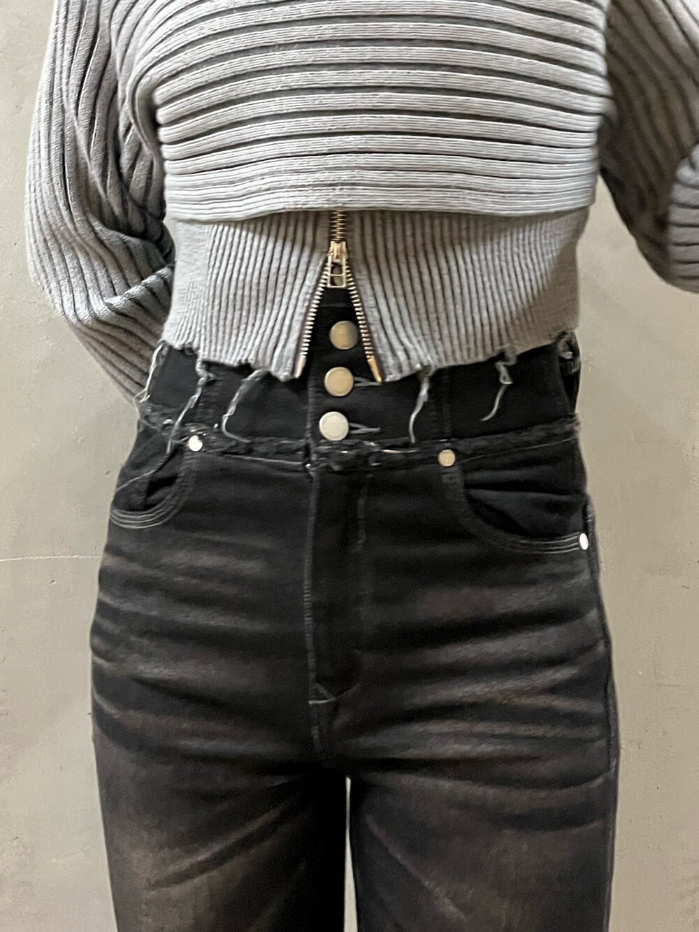 グレー系のニット/セーター、ブラック系のデニムパンツ、ブラック系のブーツを着用したレディースの秋コーディネートの4枚目の写真