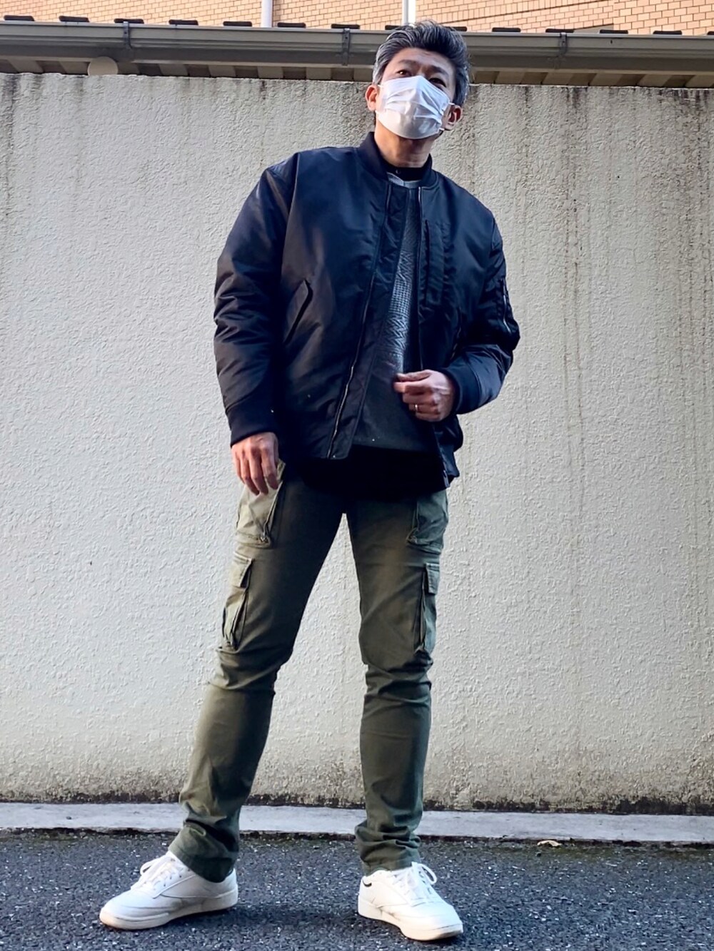 グリーン系のスニーカー、グリーン系のカーゴパンツ、グレー系のニット/セーターを着用したメンズの冬コーディネートの4枚目の写真