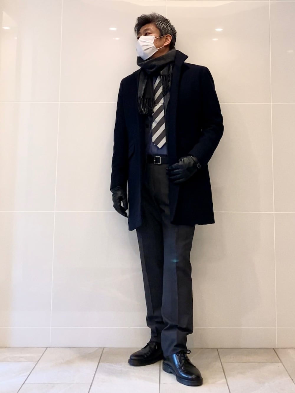 ブラック系のドレスシューズ、グレー系のスーツセット、ブルー系のその他アウターを着用したメンズの冬コーディネートの2枚目の写真