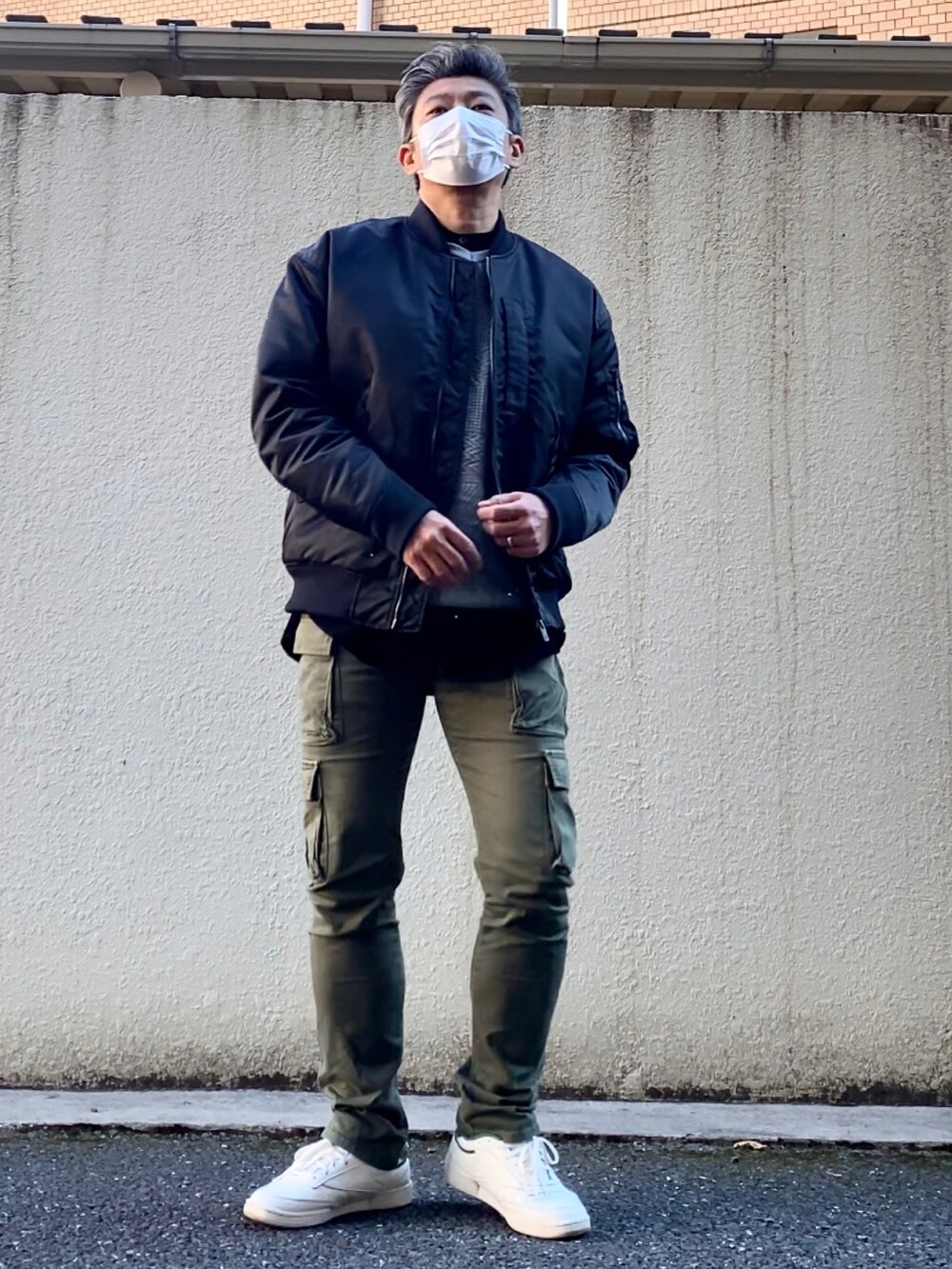 グリーン系のスニーカー、グリーン系のカーゴパンツ、グレー系のニット/セーターを着用したメンズの冬コーディネートの2枚目の写真