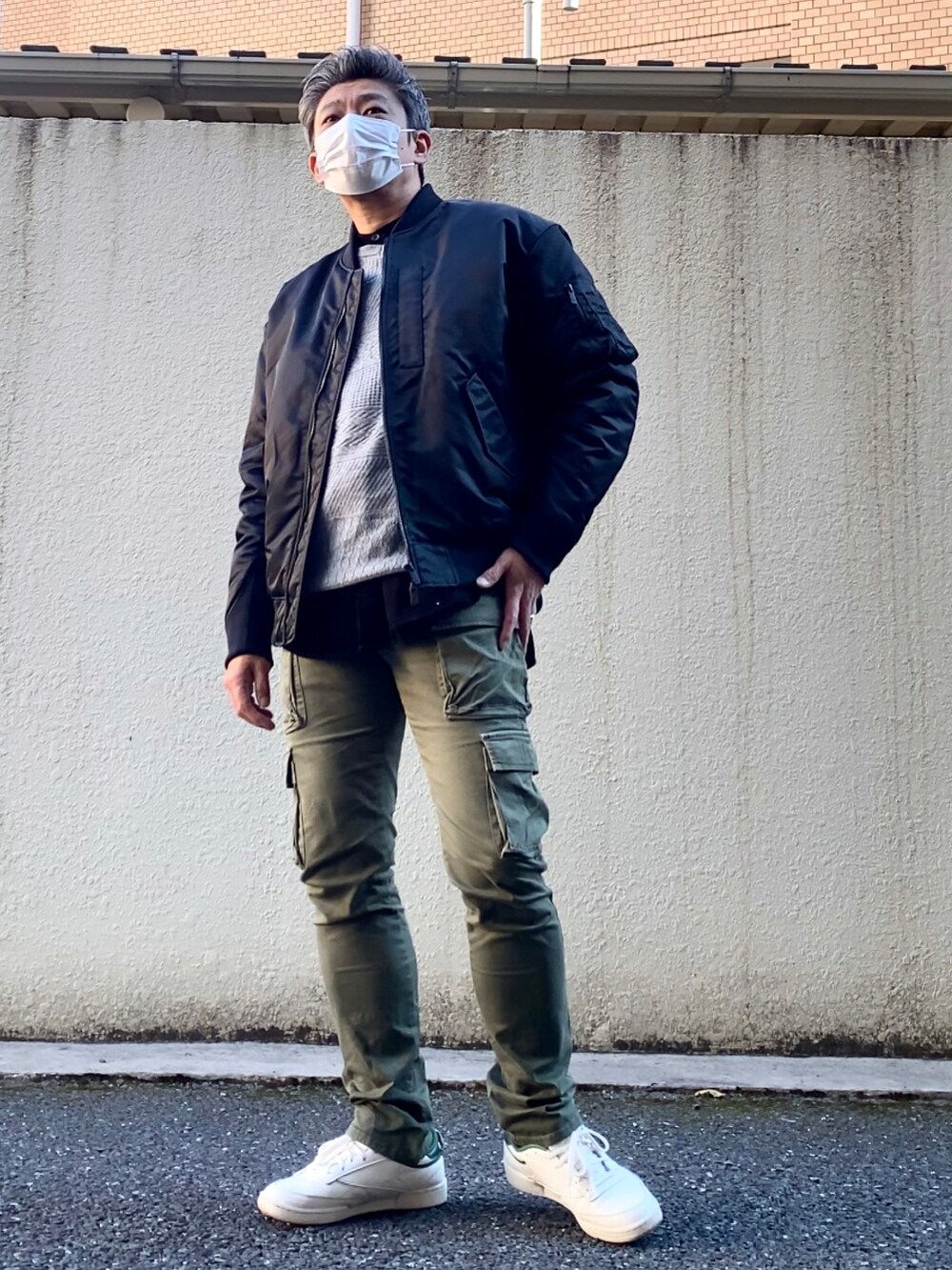 グリーン系のスニーカー、グリーン系のカーゴパンツ、グレー系のニット/セーターを着用したメンズの冬コーディネートの3枚目の写真