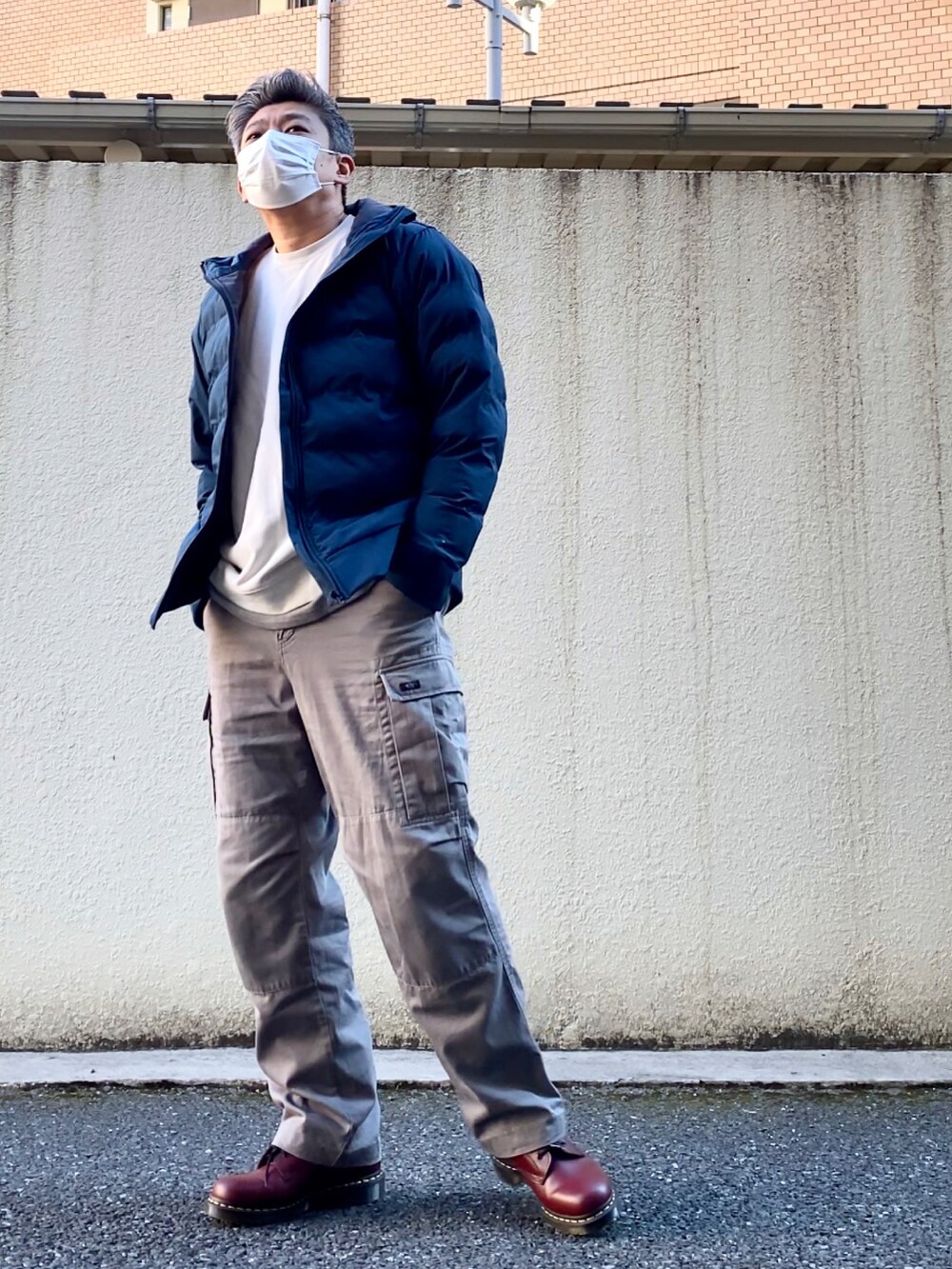 レッド系のブーツ、グレー系のカーゴパンツ、グレー系のTシャツ/カットソーを着用したメンズの冬コーディネートの2枚目の写真