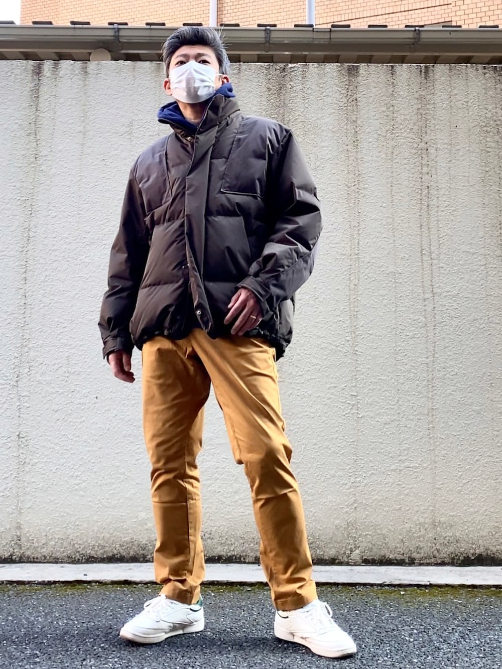 イエロー系のチノパンツ、グリーン系のスニーカー、その他のダウンジャケット/コートを着用したメンズの冬コーディネートの3枚目の写真