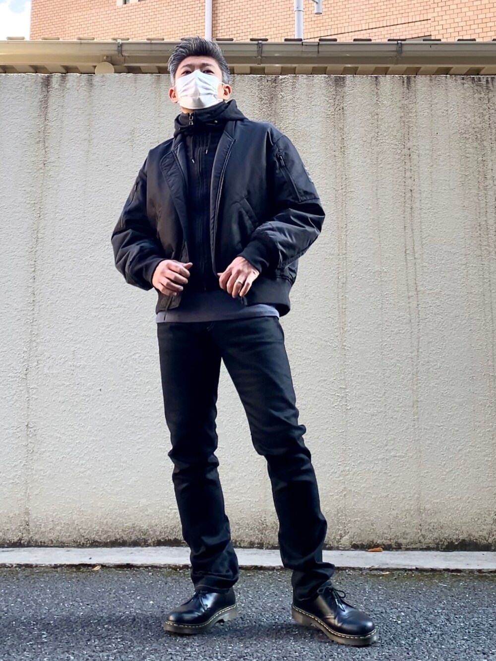 ブラック系のドレスシューズ、ブラック系のデニムパンツ、ブラック系のMA-1を着用したメンズの冬コーディネートの2枚目の写真
