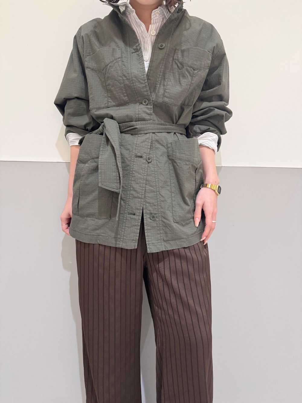 グリーン系のその他アウター、ブラウン系のその他パンツ、ホワイト系のシャツ/ブラウスを着用したレディースの春コーディネートの4枚目の写真