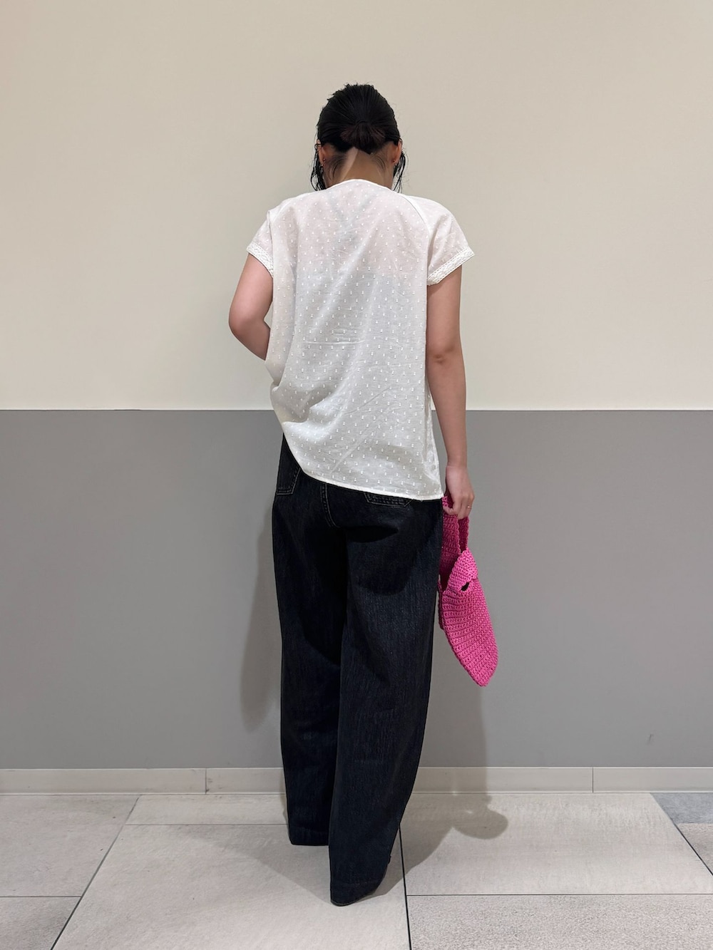 ブラック系のデニムパンツ、ホワイト系のシャツ/ブラウス、ピンク系のかごバッグを着用したレディースの夏コーディネートの3枚目の写真