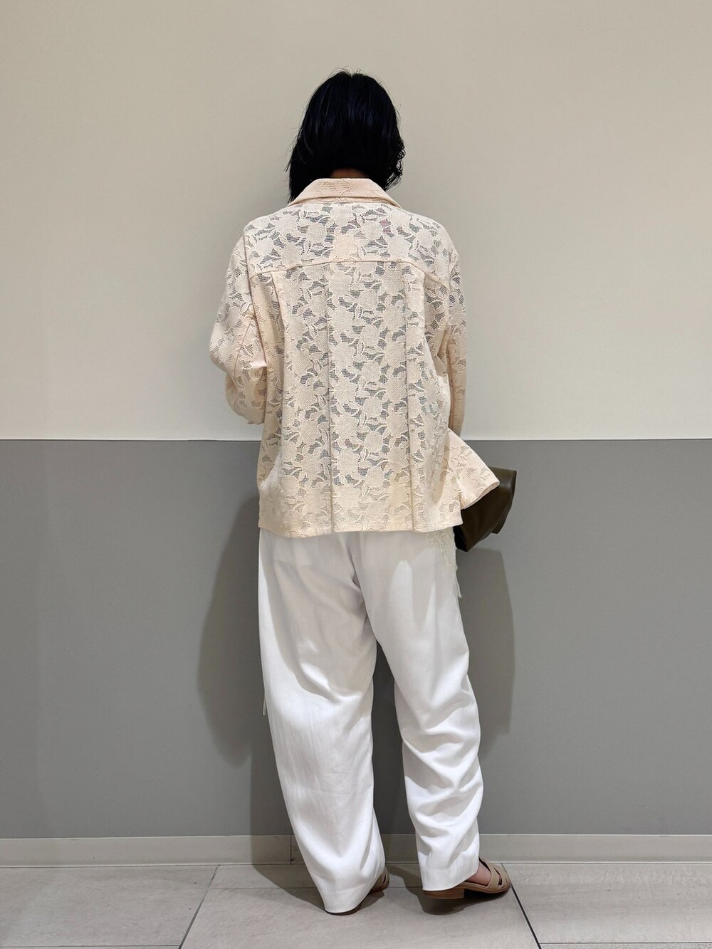 ホワイト系のスラックス、ホワイト系のシャツ/ブラウス、ブルー系のTシャツ/カットソーを着用したレディースの春コーディネートの3枚目の写真