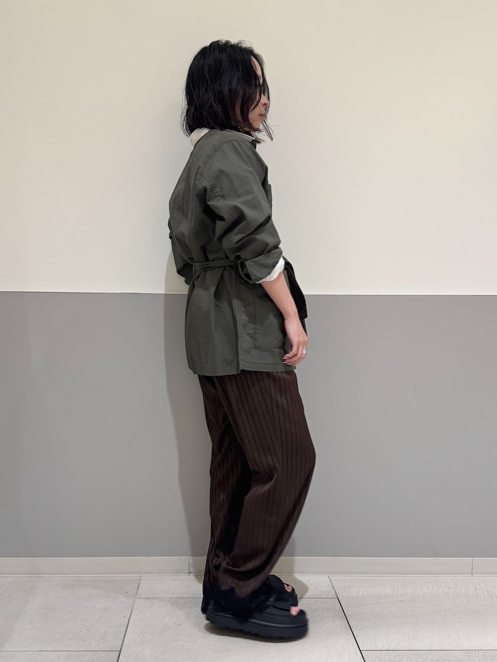 グリーン系のその他アウター、ブラウン系のその他パンツ、ホワイト系のシャツ/ブラウスを着用したレディースの春コーディネートの2枚目の写真