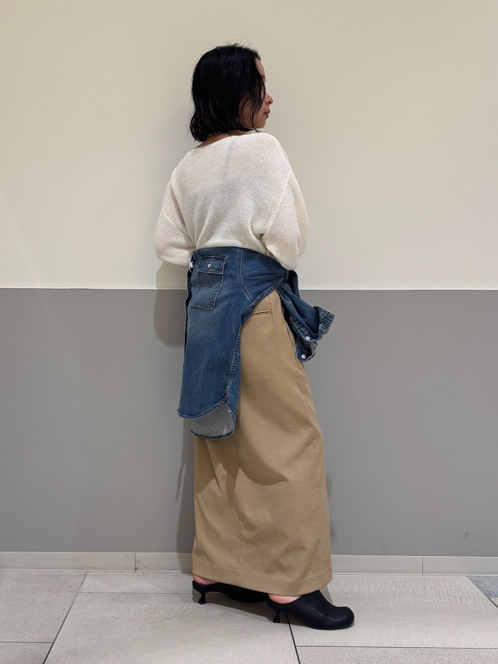 ブルー系のシャツ/ブラウス、ベージュ系のスカート、ホワイト系のニット/セーターを着用したレディースの春コーディネートの2枚目の写真