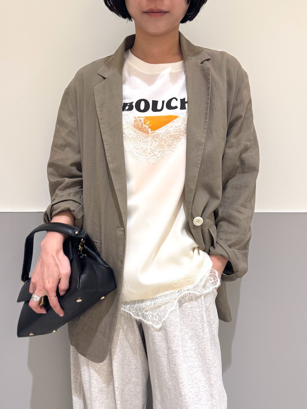 ブラウン系のテーラードジャケット、グレー系のスウェットパンツ、ホワイト系のキャミソールを着用したレディースの春コーディネートの5枚目の写真