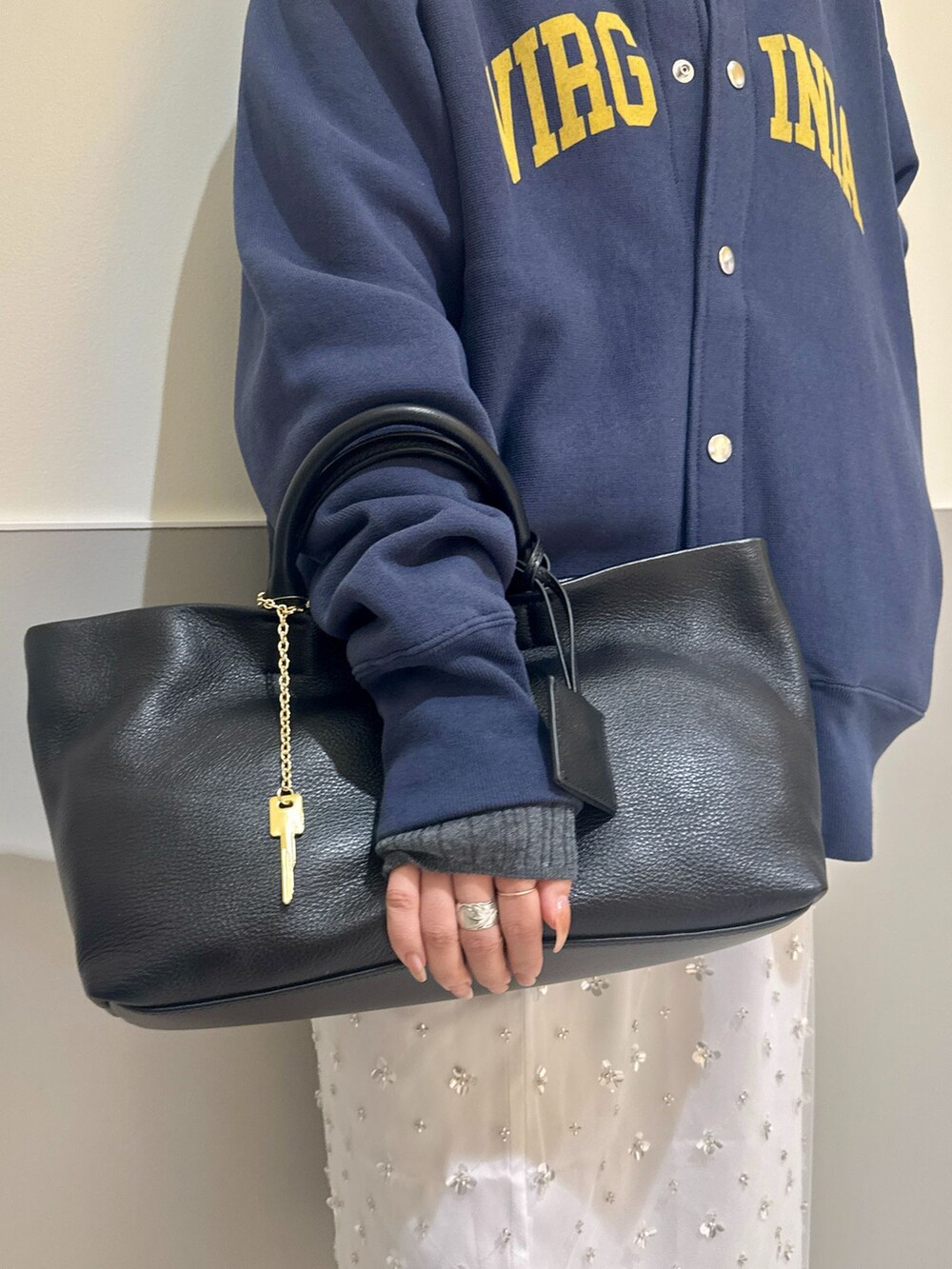ホワイト系のスカート、ブルー系のカーディガン/ボレロ、グレー系のニット/セーターを着用したレディースの秋コーディネートの6枚目の写真