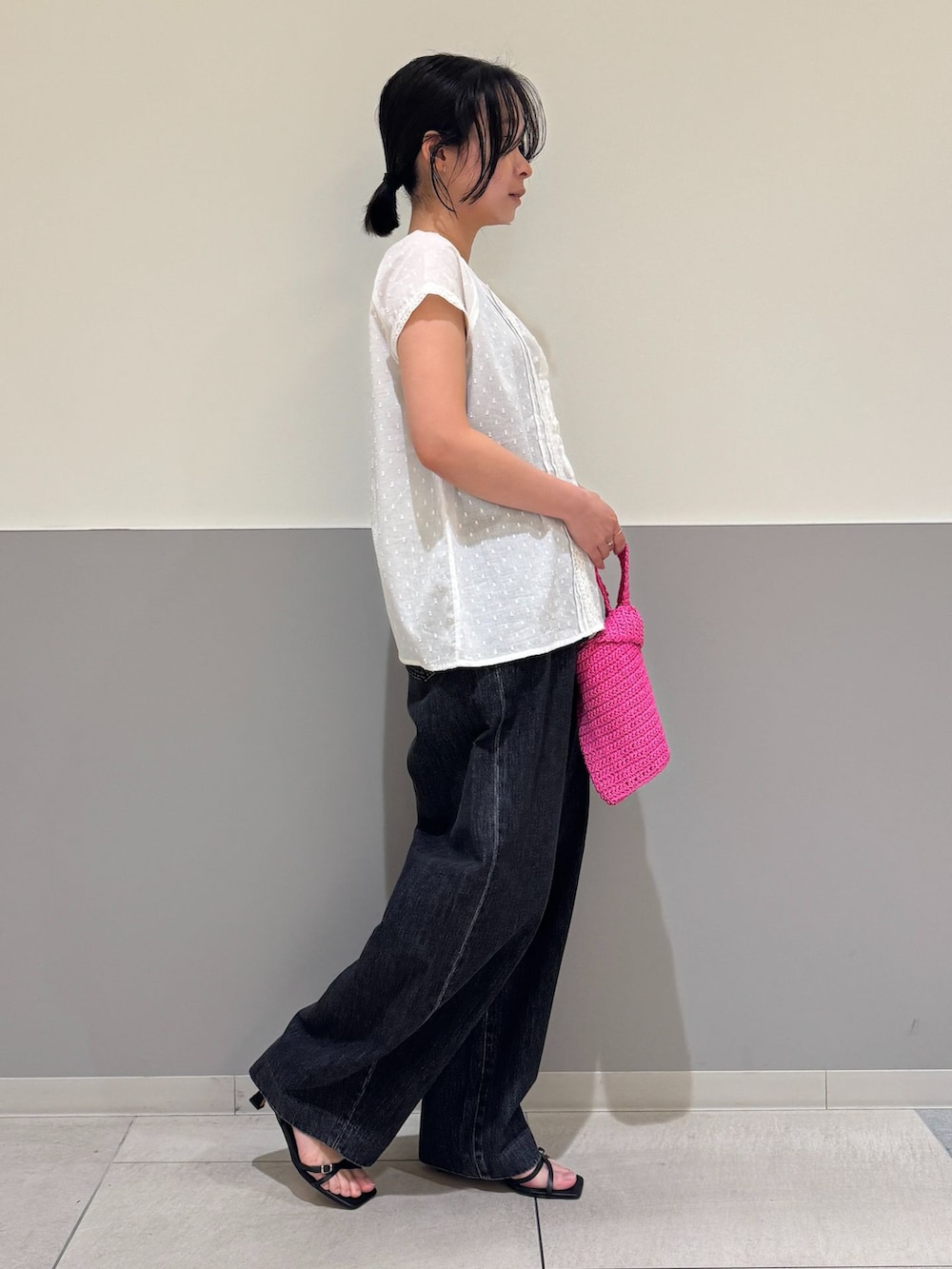 ブラック系のデニムパンツ、ホワイト系のシャツ/ブラウス、ピンク系のかごバッグを着用したレディースの夏コーディネートの2枚目の写真